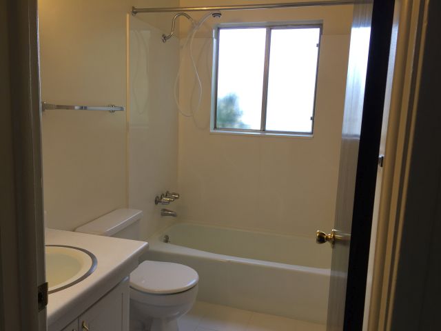 Bath has shower wand & acrylic tub surround