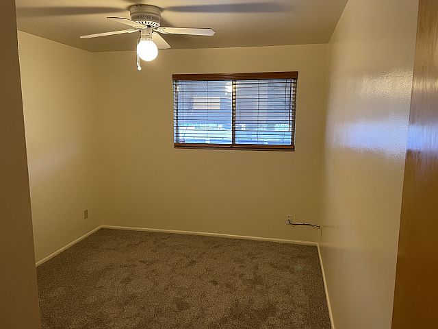 bedroom with large window & ceiling fan